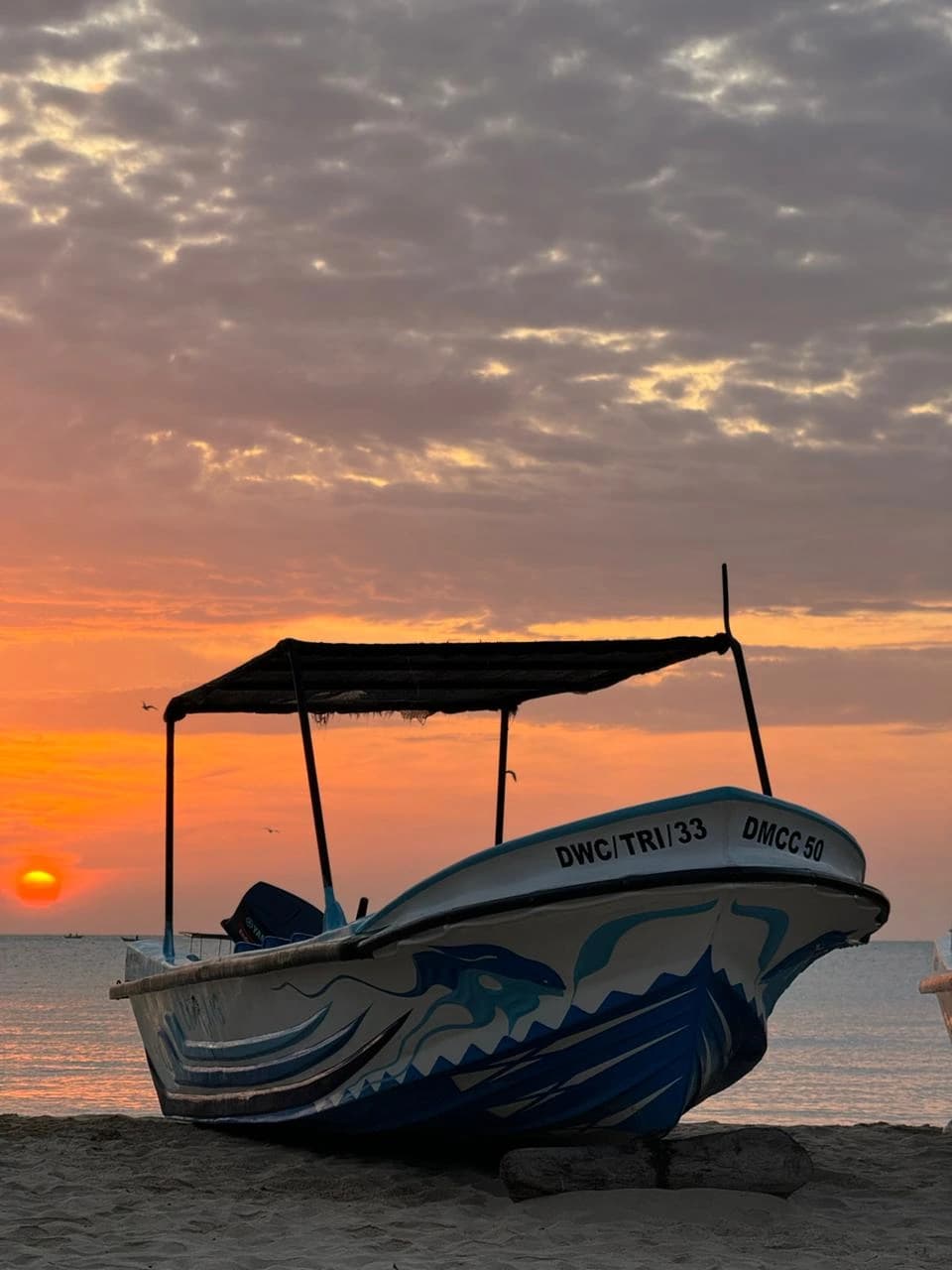 Dive boat on the beach at sunrise in Trincomalee, Sri Lanka